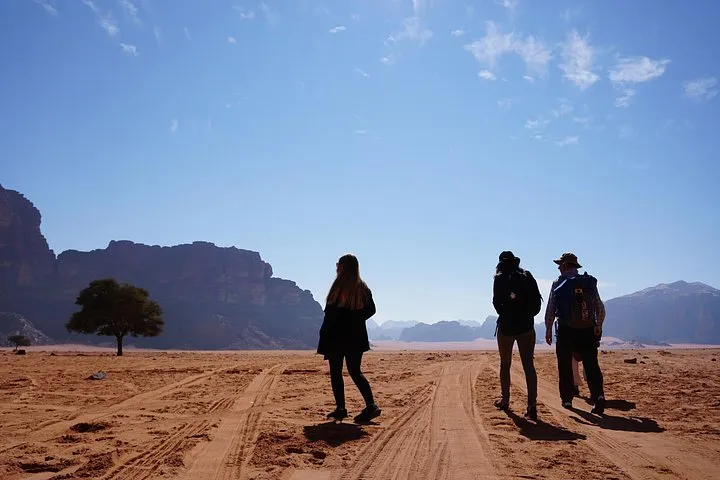 Hiker walking between sandstone formations on a Wadi Rum full-day jeep and hiking tour in Jordan