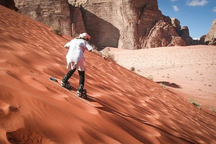 Camel caravan on red desert sand during a Wadi Rum half-day jeep and camel tour in Jordan