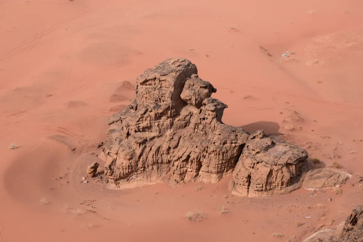 A rock island seen from above on red sand in Wadi Rum, Jordan, the kind of view reachable without a tour